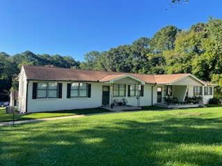 Shows the front of a three unit, brick, rowhouse